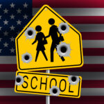 School Sign with Bullet holes over American flag